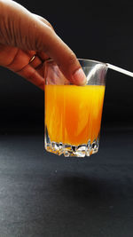 Close-up of hand holding drink on table