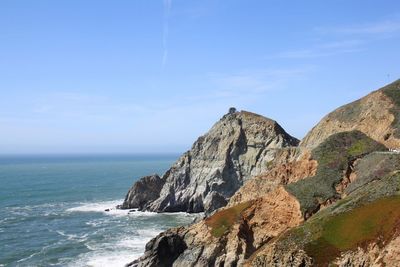 Scenic view of sea and mountains against sky