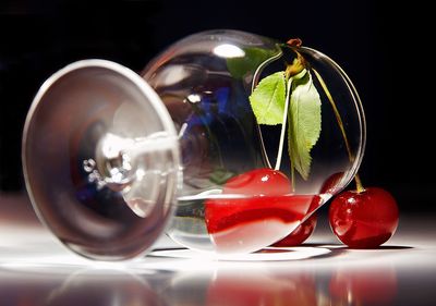 Close-up of glass with cherries and water tipped over