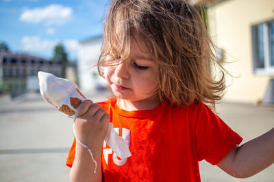 Little caucasian girl holding melting ice cream cone