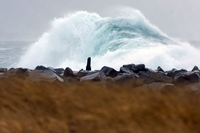 Panoramic shot of rocks on beach against sky