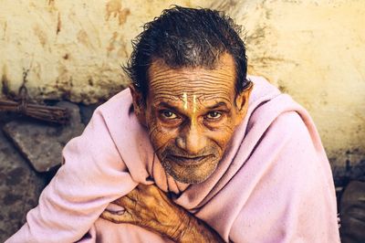 High angle portrait of mature man wrapped in blanket sitting outdoors