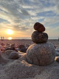 Stack of stones on beach during sunset