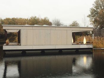 Reflection of building in lake against clear sky