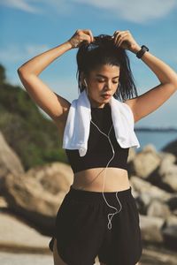 Portrait of young woman standing at beach