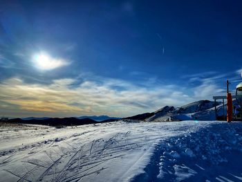 Snow covered landscape against sky