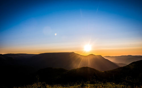 Scenic view of silhouette mountains against sky at sunset