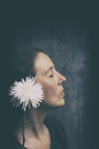 Woman in melancholic attitude with white chrysanthemum xii
