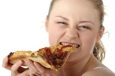 Portrait of young woman eating ice cream over white background