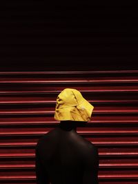 Close-up of mannequin wearing yellow bucket hat by closed shutter