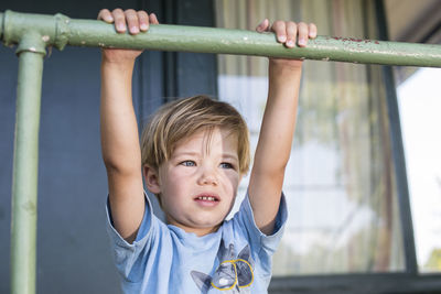 Close-up of boy hanging on playground