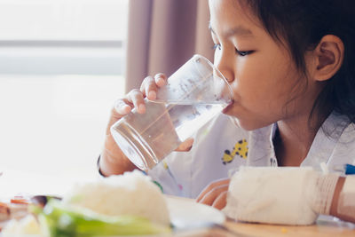 Midsection of a woman drinking water from glass