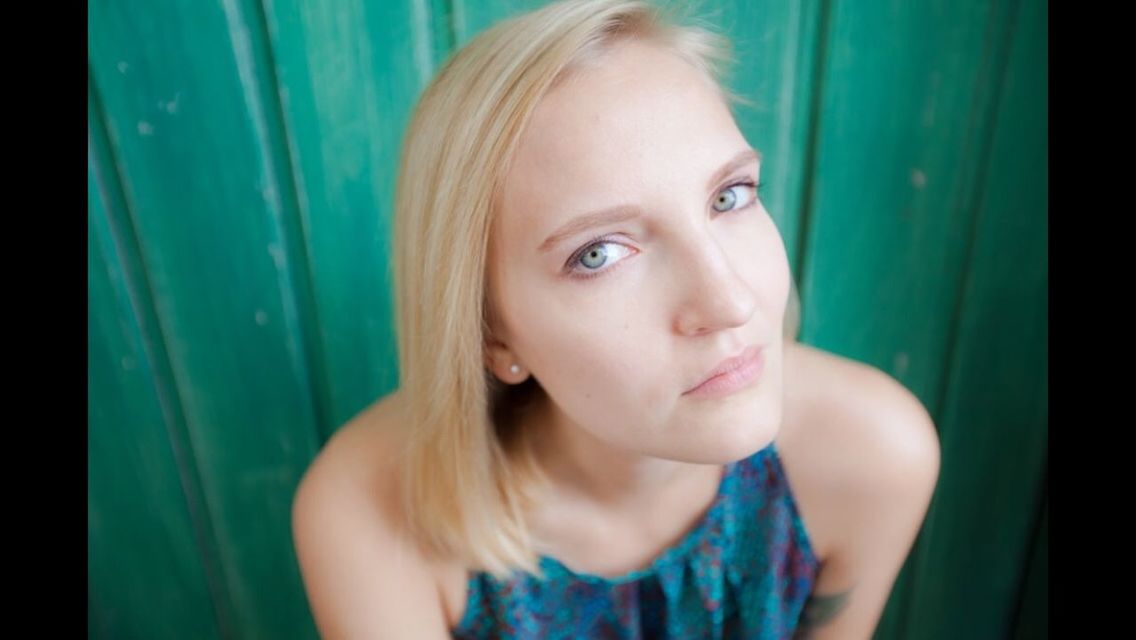 portrait, looking at camera, person, headshot, young adult, indoors, young women, lifestyles, front view, close-up, leisure activity, long hair, smiling, human face, head and shoulders, casual clothing, contemplation