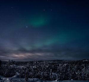 Scenic view of snowcapped landscape against sky at night