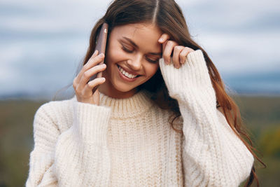 Portrait of young woman standing at beach