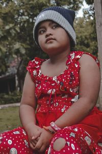 Girl looking away while sitting outdoors