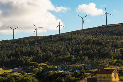 Windmills on field against sky