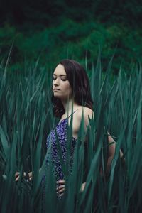 Side view of young woman standing on field