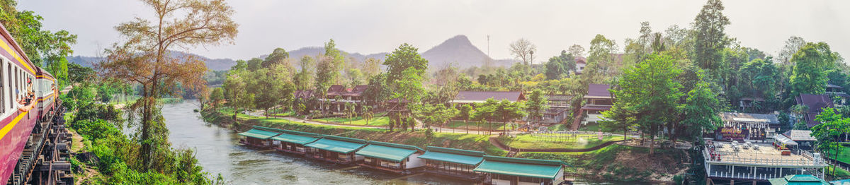 Panoramic shot of canal amidst trees against sky