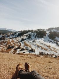 Low section of man on snow covered sand against sky