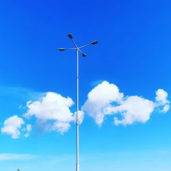 Low angle view of street light against blue sky