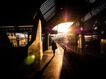Man and woman standing on railroad station platform at night