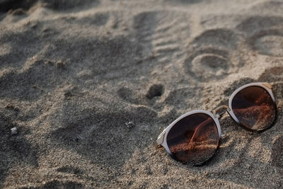 Close-up of sunglasses on sand