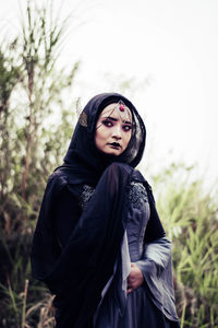 Young woman wearing witch costume while standing outdoors