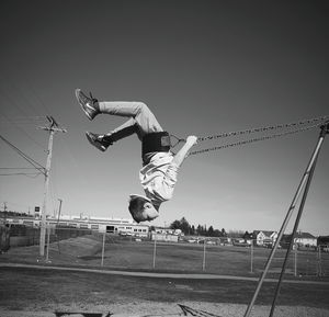 Full length of man swinging on swing against sky