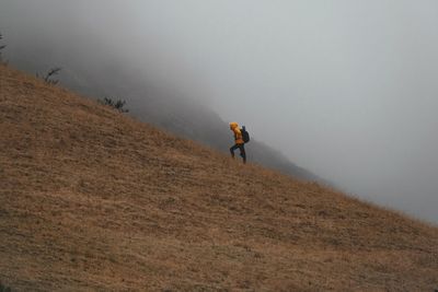 Man walking on street during foggy weather