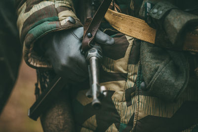 Midsection of soldier holding gun