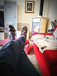 Low section of man sitting on sofa at home