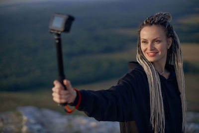 Portrait of smiling woman photographing