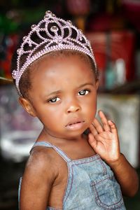 Close-up portrait of cute baby girl wearing crown at home