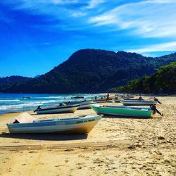 Boats moored on beach against sky