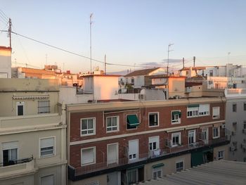 Residential buildings against sky during sunset