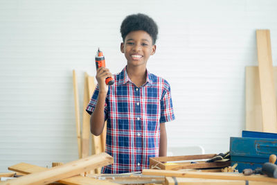 Portrait of smiling young man standing in workshop