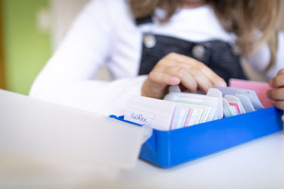 Midsection of woman with cards on table