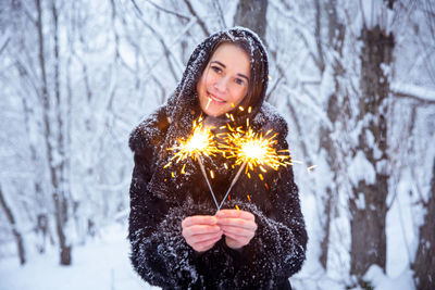 Portrait of smiling woman holding snow