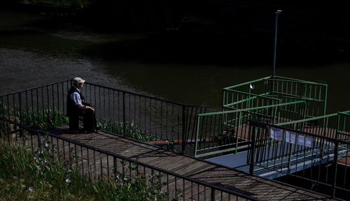 Rear view of man walking on footbridge