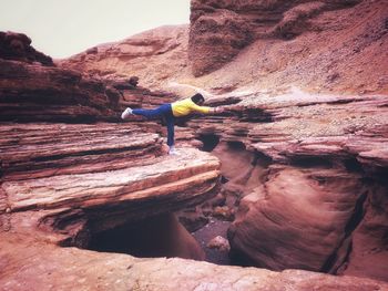 Man doing yoga on rock formation
