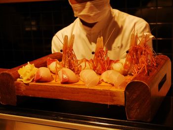 Chef in front of sushi and lobsters on tray in restaurant