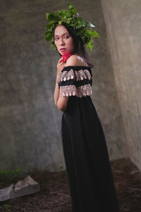 Portrait of woman standing against wall