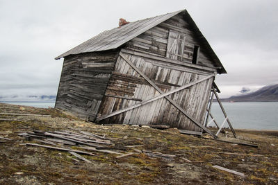 Abandoned building on field against sky