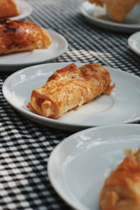 Close-up of croissants in plates on tablecloth