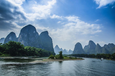 Scenic view of river and mountains against sky