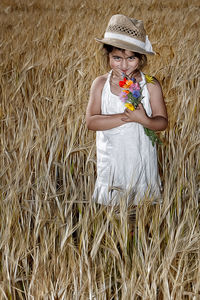 Midsection of woman wearing hat in farm