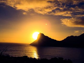 Scenic view of sea against dramatic sky during sunset