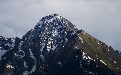 Low angle view of snowcapped mountain against sky