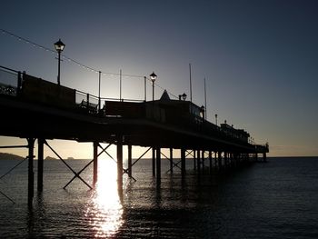 Pier on sea at sunset